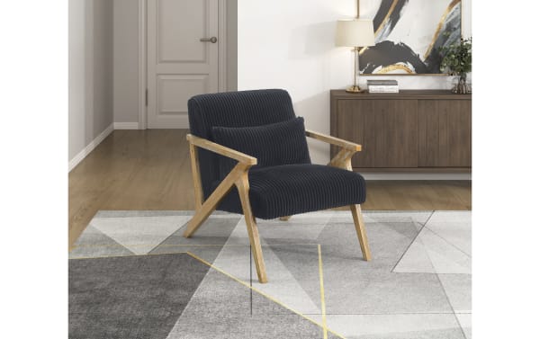 Baylor Black Accent Chair with mid-century modern design, black polyester fabric upholstery, distressed natural wood frame, and included lumbar pillow.