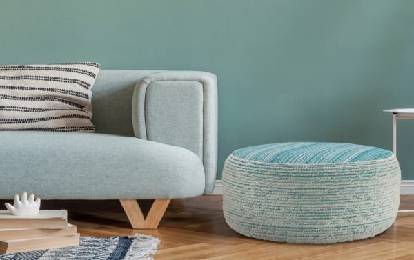 Mid-century modern Dani Aqua Pouf in textured aqua and white woven polyester fabric, styled as a versatile footrest or extra seat.