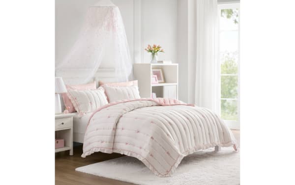 Maison Full/Queen Pink 3 Piece Quilt Set with white microfiber, pink bow embroidery, ruffled edges, and down-alternative loft for cozy, stylish bedding.