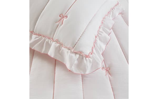 Maison Full/Queen Pink 3 Piece Quilt Set in white microfiber with pink bow embroidery, ruffled edges, and down-alternative fill for cozy, stylish bedding.