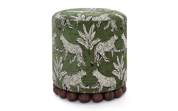 Green cylindrical fabric ottoman with white leopard and leaf patterns, featuring a wooden bead base for stylish living room seating or decor.