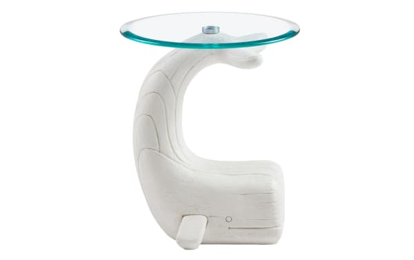 White wooden side table shaped like a whale with a curved tail supporting a round clear glass top, modern nautical decor.