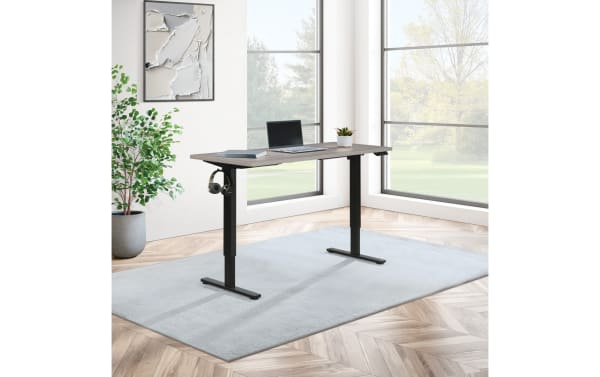 Carl Gray 60'' adjustable height sit-to-stand desk in transitional style with gray MDF top and black painted steel frame, featuring touch controls and sturdy steel legs.