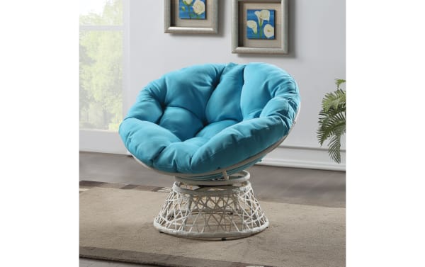 Round papasan chair with a white woven rattan base and thick, tufted turquoise cushion, ideal for cozy indoor seating.