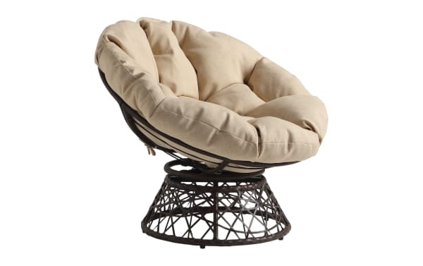 Round papasan chair with dark brown rattan frame and beige tufted cushion, designed for comfortable indoor or outdoor seating.