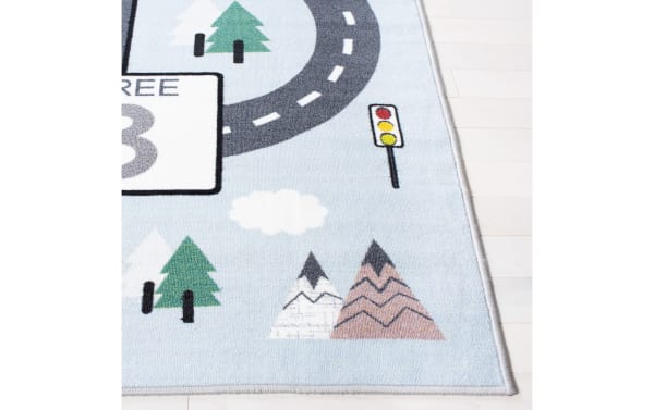 Happy Hopper 2' x 8' light blue transitional runner rug with playful road, number block, trees, mountains, and traffic light design. Soft polyamide fabric, washable, slip-resistant backing, OEKO-TEX certified.