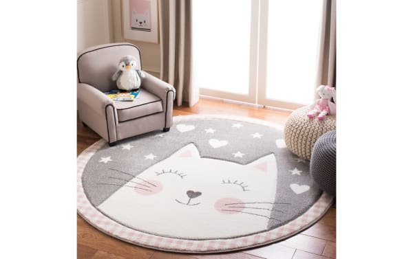 Kitten Cuddles 4' round pink rug with playful cat face, hearts, stars, and gingham border in soft pink, gray, and white polypropylene fabric.