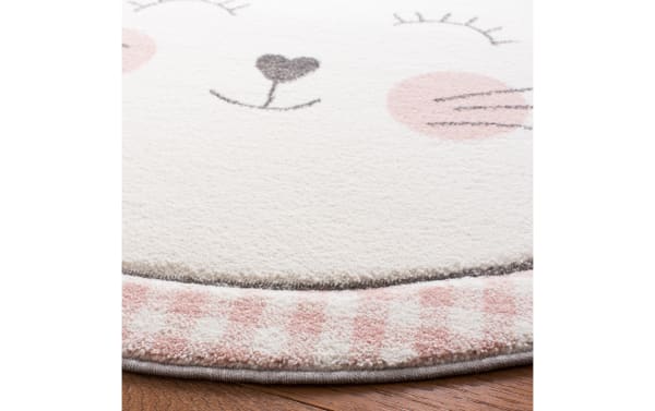 Kitten Cuddles 4' round pink rug with playful cat face, heart nose, and gingham border in soft polypropylene for kids’ rooms.