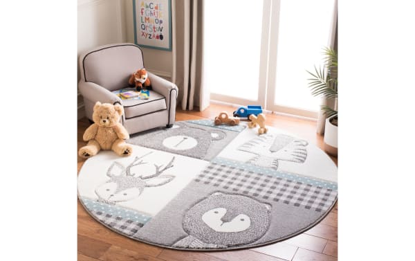 Forest Friends 4' round light blue transitional rug with gray and ivory animal faces, made of durable polypropylene and polyester fabric, soft for kids.