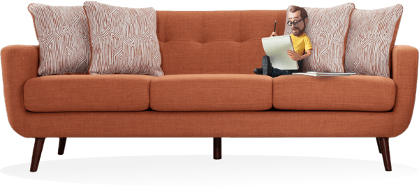 Little Bob, a caricature figurine of the founder of Bob's Discount Furniture, with a beard and wearing a yellow shirt, sits on a large orange sofa. He is sketching on paper and is surrounded by colorful patterned cushions.