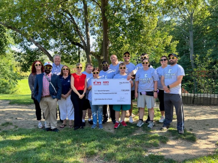 Group of people outdoors holding a large check from Bob's Furniture for $32,000 donated to Special Olympics, dated Aug. 28, 2023.