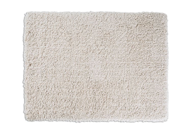 Soft beige rectangular shaggy area rug with thick, plush pile texture, suitable for living room or bedroom floor decor.