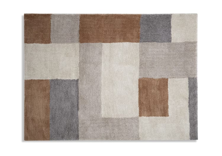 Rectangular area rug with a modern geometric pattern in beige, brown, and gray tones, featuring a soft, plush texture ideal for living rooms or bedrooms.