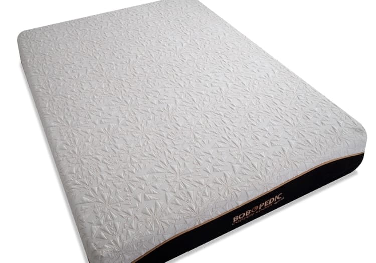 Queen-size mattress with white textured fabric cover featuring geometric patterns, black sides, and "BOBOPEDIC COMFORT EXPERT" branding on the side panel.