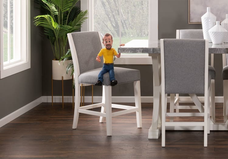 Modern dining area with gray upholstered chairs featuring white wooden frames, a marble-top table, dark hardwood flooring, and a tall green plant in a white pot.