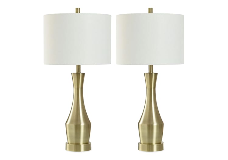 Pair of modern table lamps with brushed brass bases and white drum fabric shades, ideal for living room or bedroom lighting.