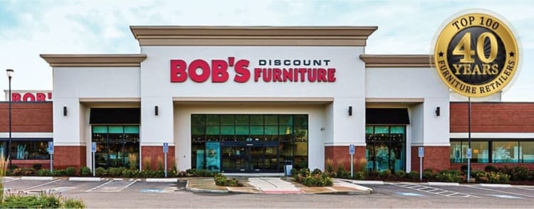 BOB'S Discount Furniture storefront with red and black signage on a white and brick building, featuring a "Top 100 Furniture Retailers 40 Years" gold emblem.