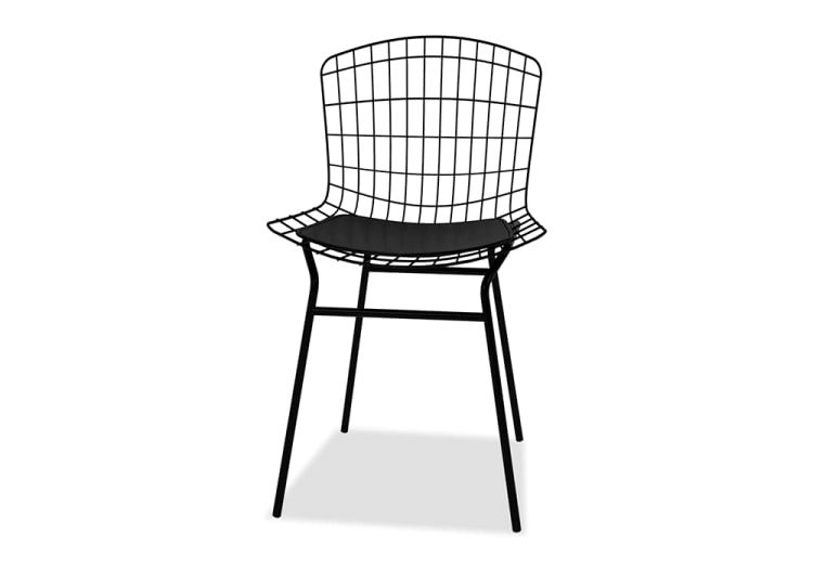 Black metal wireframe chair with curved backrest and thin legs, featuring a black cushioned seat pad for added comfort.