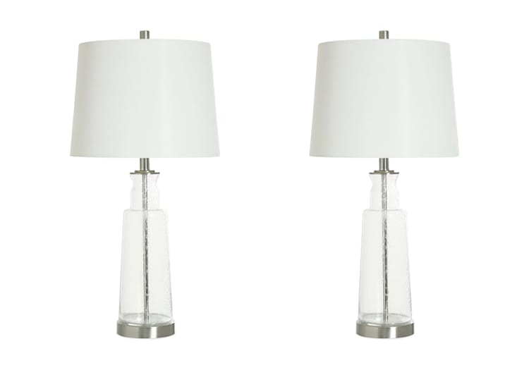 Pair of modern table lamps with clear textured glass bases, brushed nickel accents, and white drum fabric shades, ideal for living room or bedroom lighting.