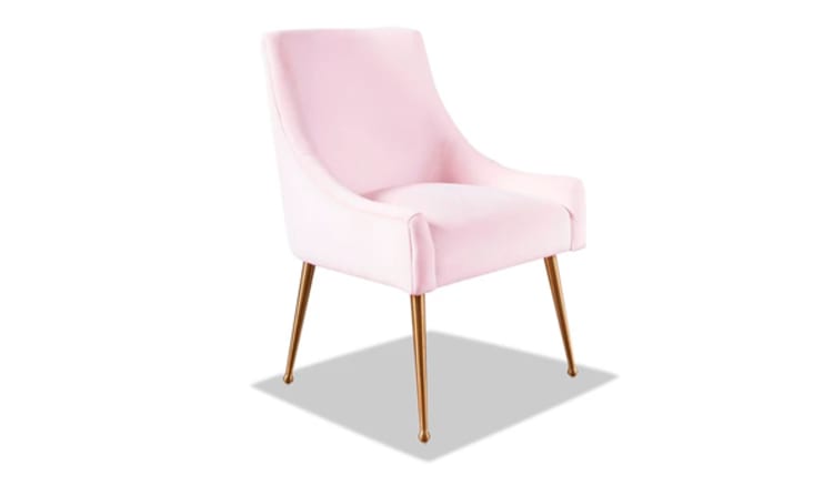 Upholstered pink velvet accent chair with curved backrest, padded seat, and slender gold metal legs, suitable for modern living spaces.