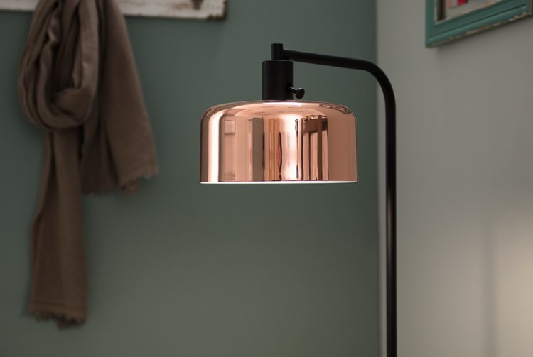 Modern floor lamp with a sleek black metal stand and a reflective copper dome-shaped shade, ideal for stylish indoor lighting.