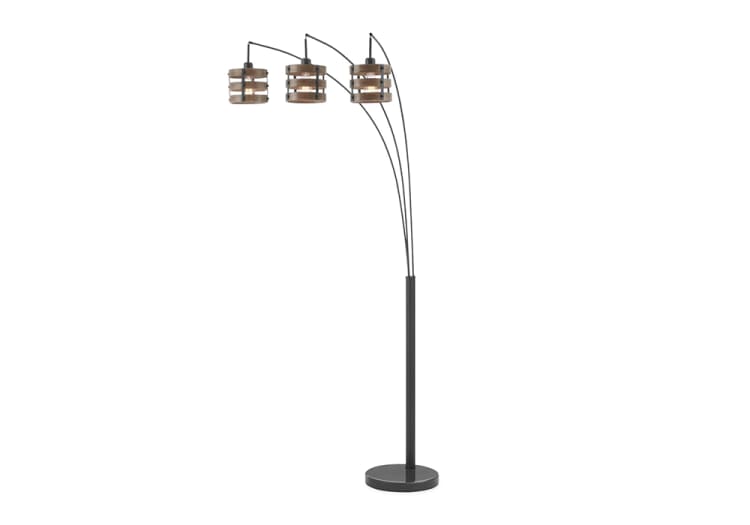 Modern black metal arc floor lamp with three adjustable wooden slat drum shades, ideal for living room or office lighting.