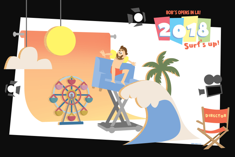 Animated banner showing a man surfing on a blue director's chair with a wave, palm tree, and Ferris wheel in the background. Text reads: "BOB'S OPENS IN LA! 2018 Surf's up!" and a red director's chair labeled "DIRECTOR." The scene combines beach and film studio elements, promoting a 2018 event or launch.