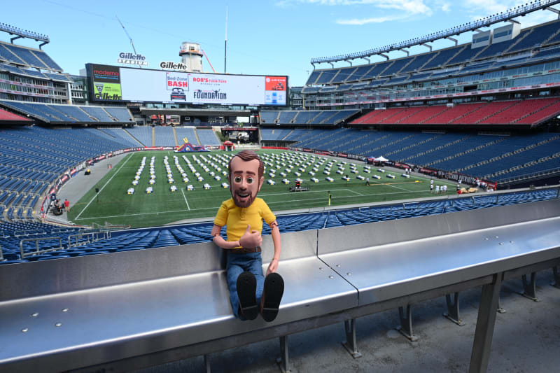 Gillette Stadium with rows of tables set up on the field for Bed-Zone Bash by Bob’s Furniture Foundation, visible scoreboard with event branding.