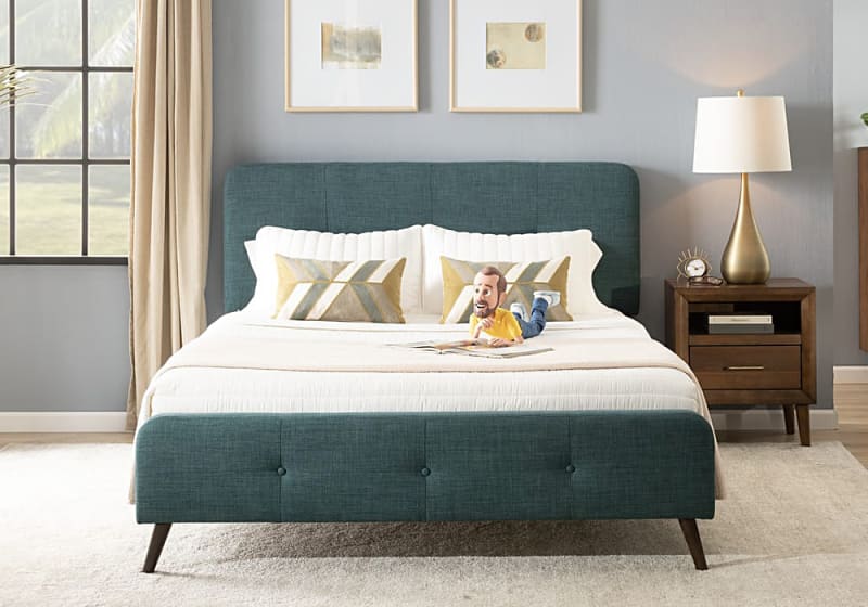 Modern bedroom with teal upholstered platform bed featuring a textured fabric headboard and footboard, white bedding, geometric accent pillows, wooden nightstand with brass lamp, and neutral decor.