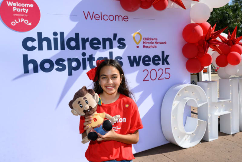 Welcome banner for Children's Hospitals Week 2025 with red and white balloons, featuring a girl in a red shirt holding a plush toy.