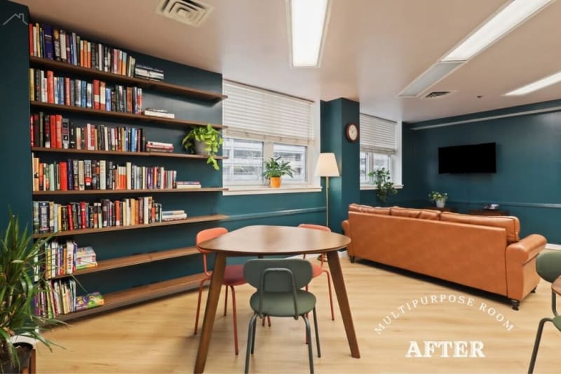 Multipurpose room with teal walls, wooden floating bookshelves filled with books, a round wooden table with chairs, brown leather sofa, and wall-mounted TV. Text reads "MULTIPURPOSE ROOM AFTER."