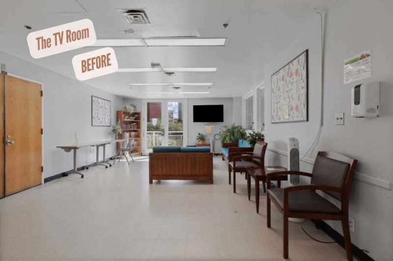 The TV room before renovation shows a spacious area with white walls, beige tile flooring, wooden framed chairs with brown cushions, a wooden sofa with blue cushions, a small wooden table, a TV mounted on the far wall, and indoor plants near a glass door. Text reads "The TV Room BEFORE."