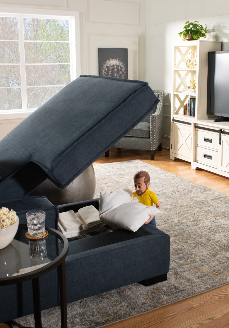 Sectional chaise storage open with little Bob putting a pillow away.