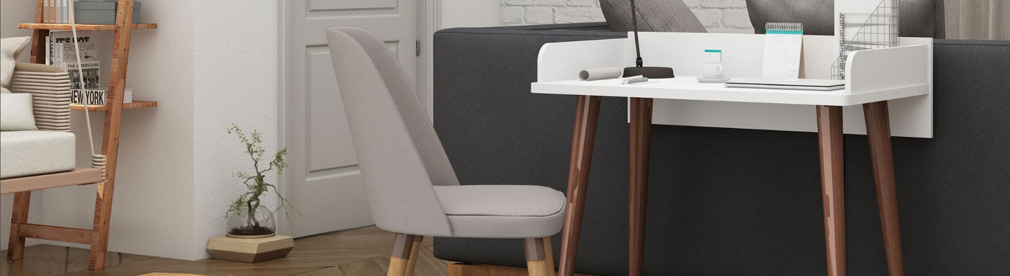 Home office with gray upholstered desk chair and a white top writing desk with brown legs that is against the back of a sofa.