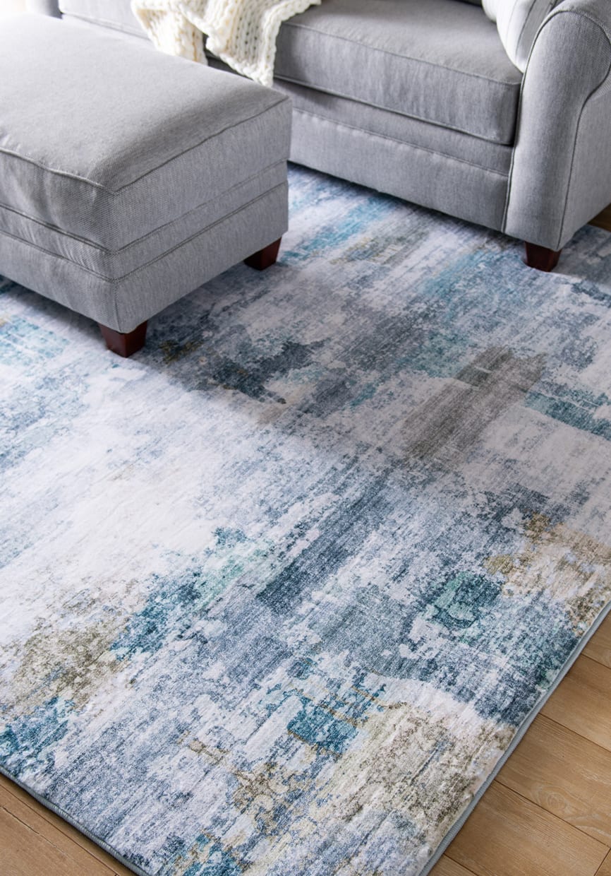blue, white, and beige abstract rug under a gray furniture set