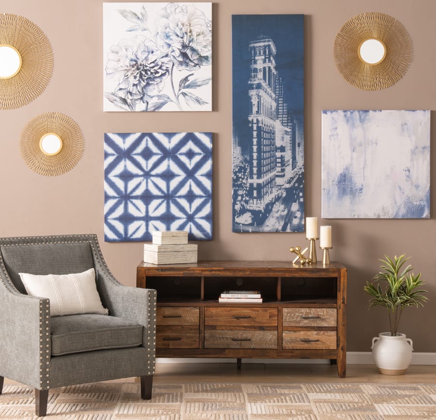 Tan wall with assortment of blue tones of wall art and gold wall decor