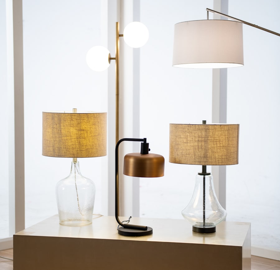 2 glass base table lamps with beige shades, one metal table lamp with bronze shade, a 2 light gold floor lamp with frosted globe shades, and an arched floor lamp with a white shade.