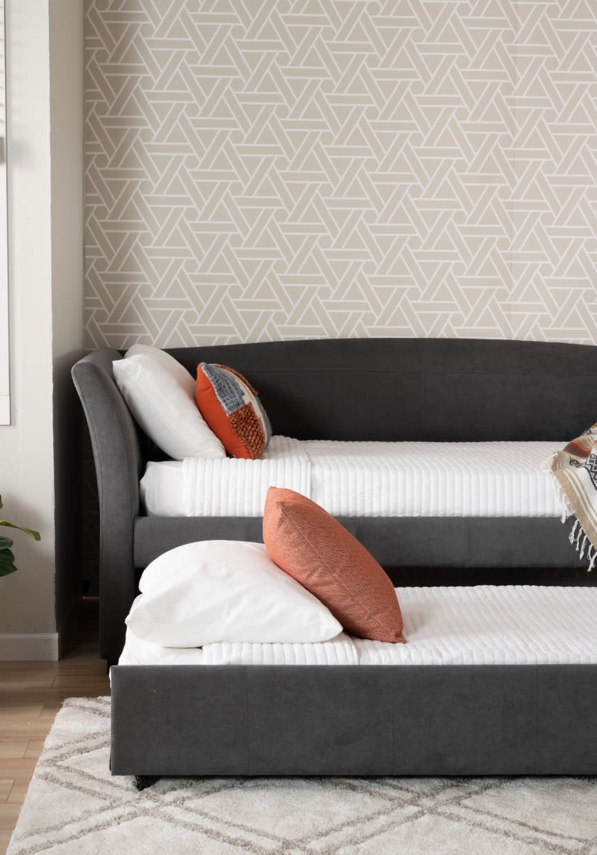 Gray daybed with trundle in whtie bedding and accent pillows.