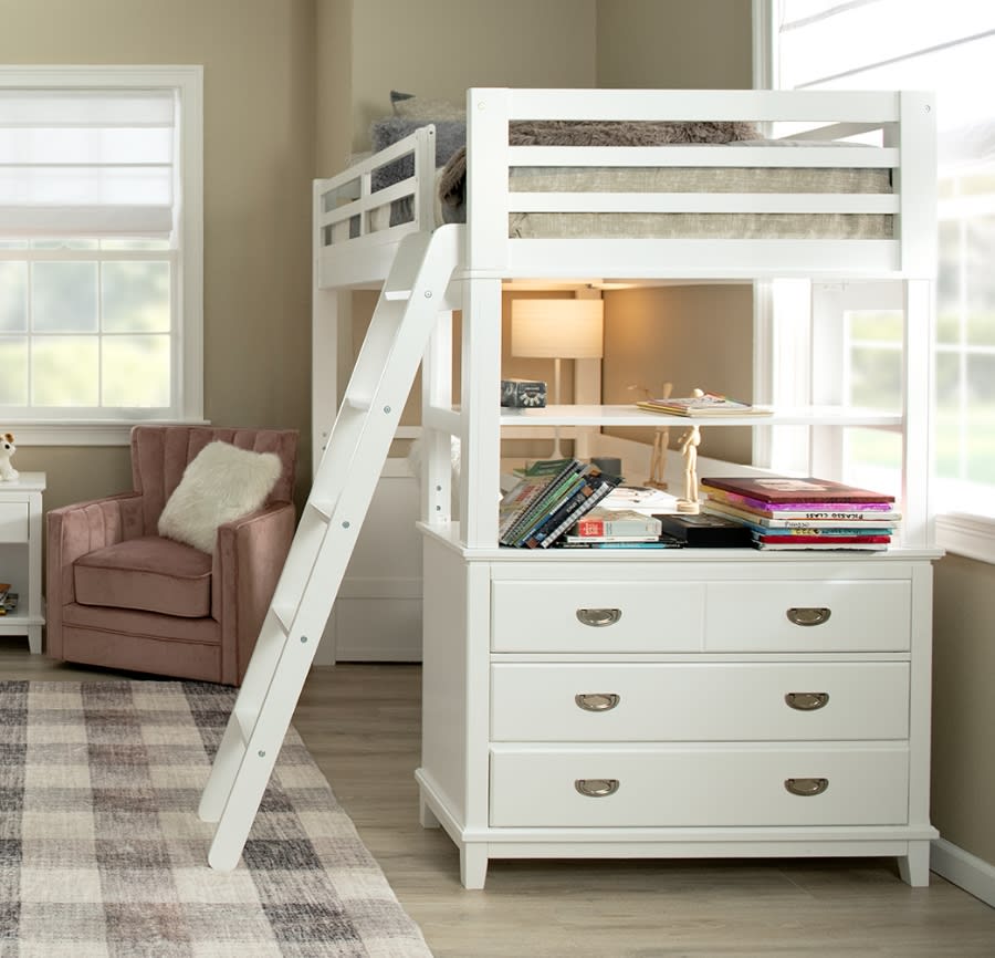 White loft bed with desk and 3 drawers on a plaid area rug.