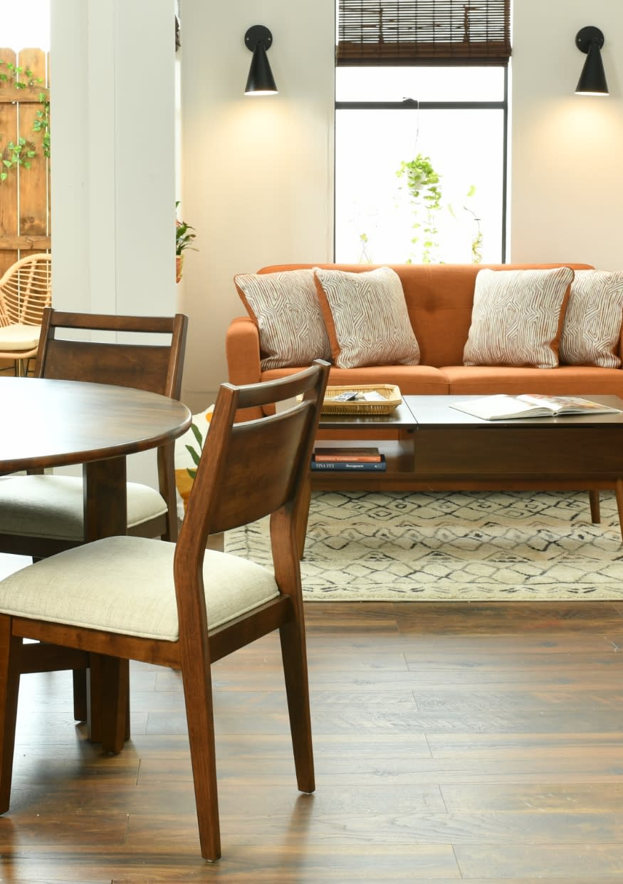 Small living space with a small round table dining set and orange sofa.