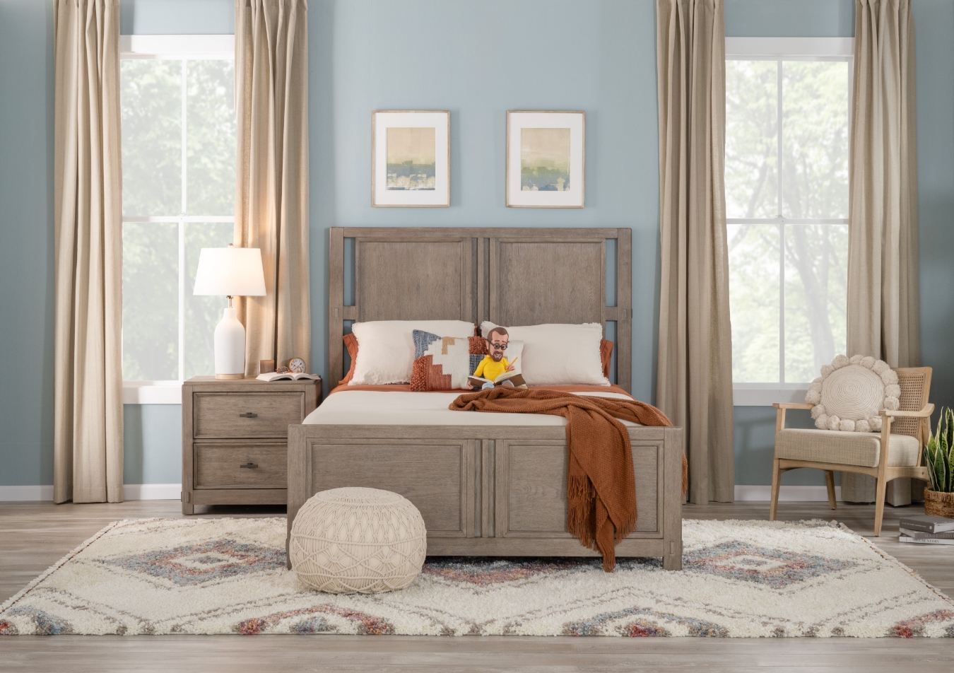 Transitional gray bedroom set, showcasing a bed with orange throw blanket and white pillows, 2 drawer nightstand with white lamp on top, 5 drawer chest, and 8 drawer dresser, with beige side chair with white cushion and white geometric accent rug