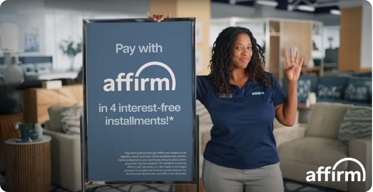Woman holding a 'Pay with Affirm' sign