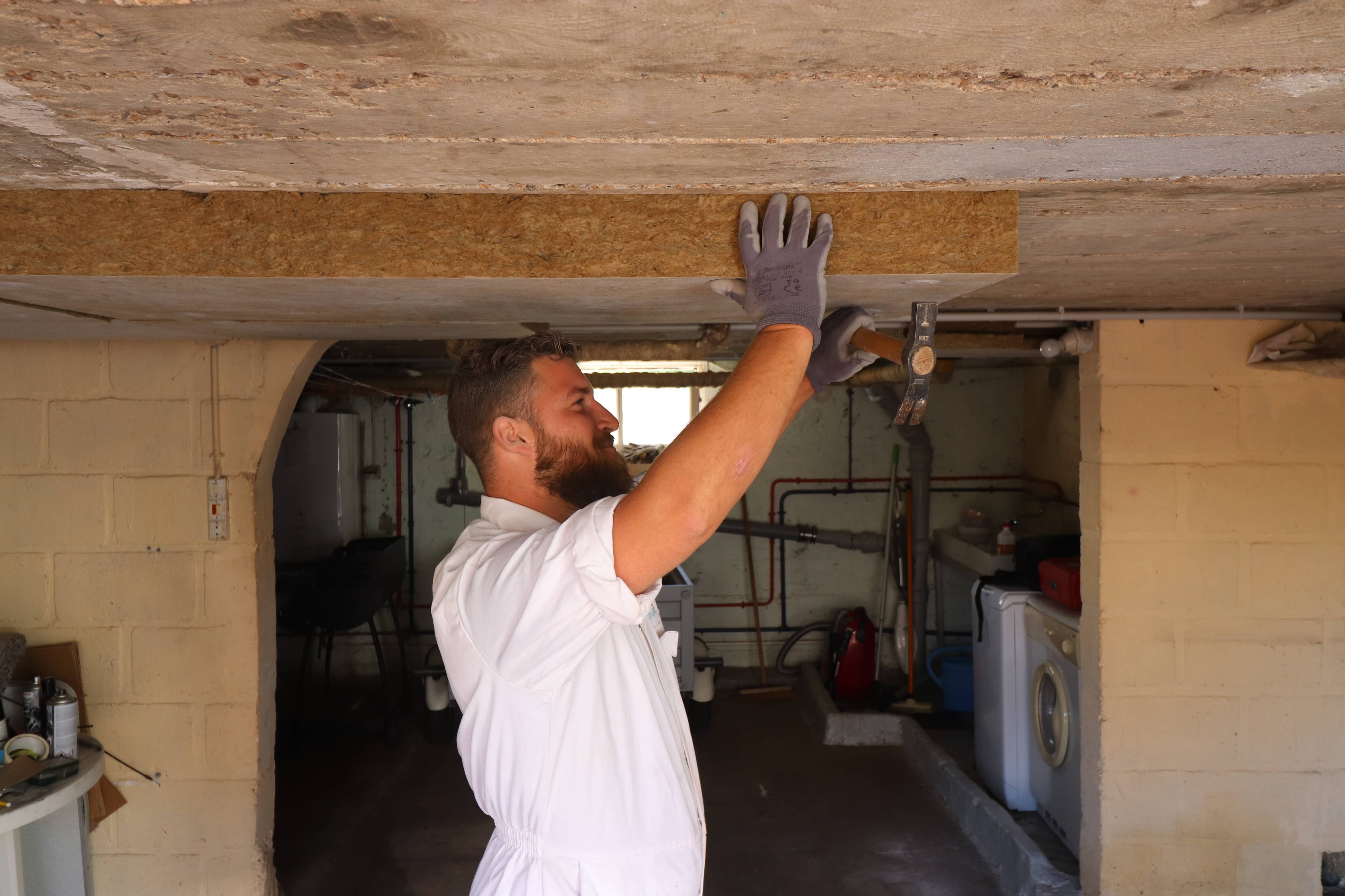 Un Homme Installe Une Couche D'isolation Thermique Sur Le Mur De L