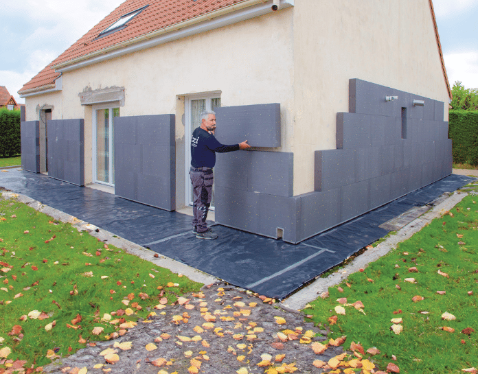 Prestataire qualifié en train de poser une isolation extérieure