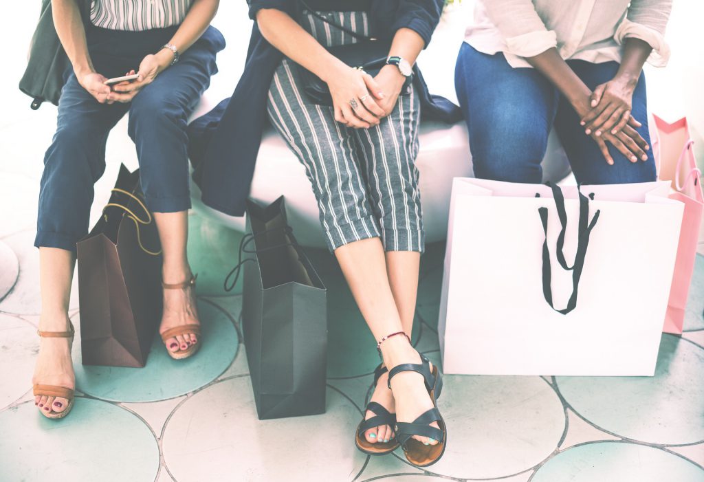 3 Women with shopping bags - in-store shopping is still preferable.