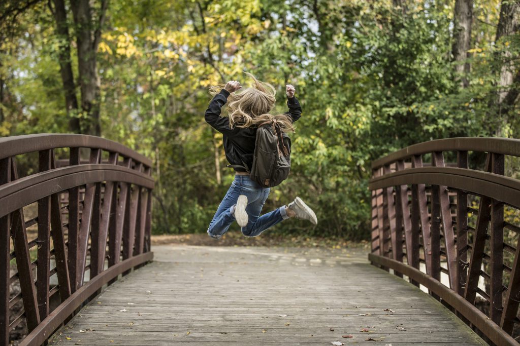 Girl jumping on bridge