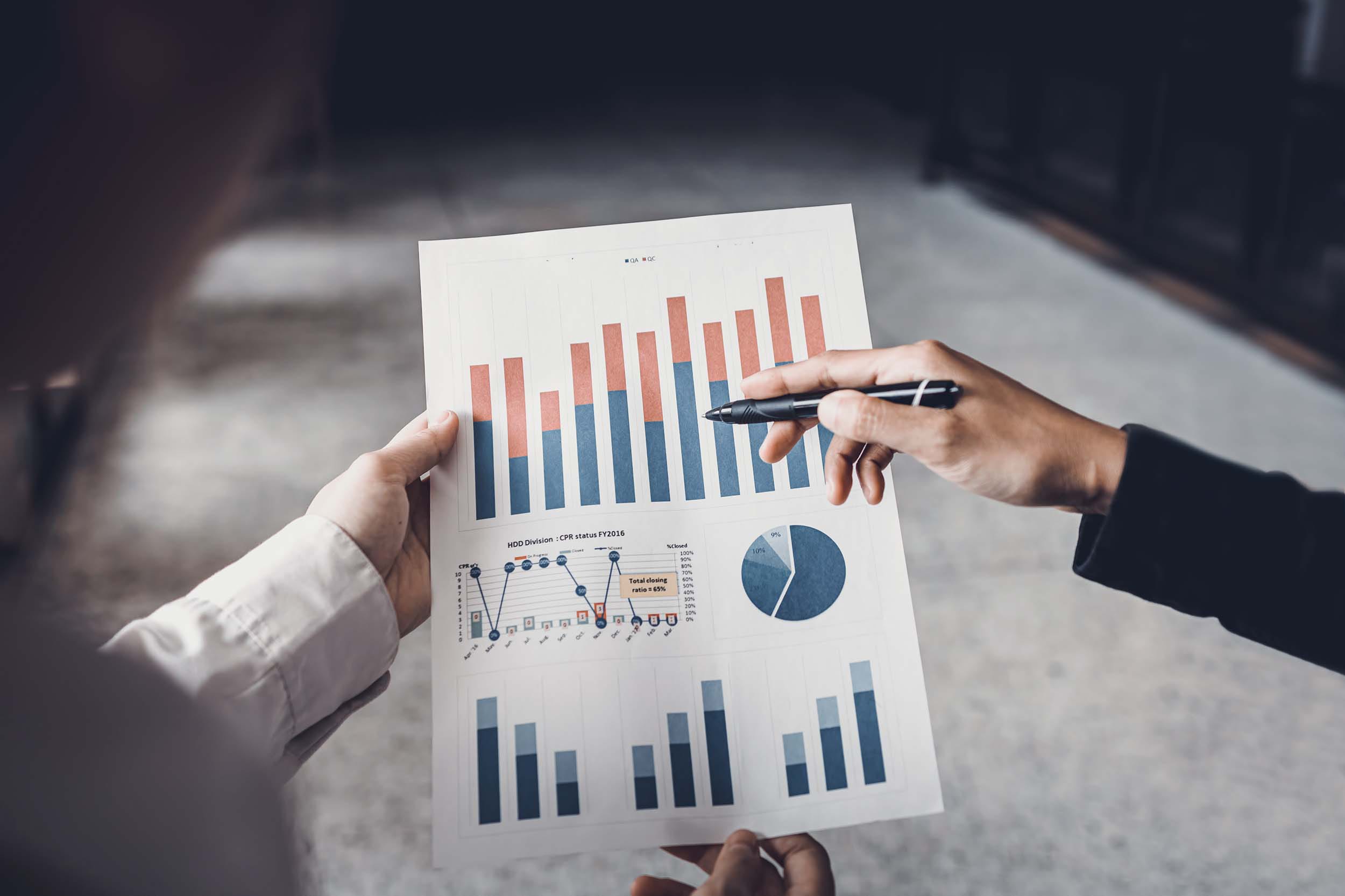 Two people holding business management report