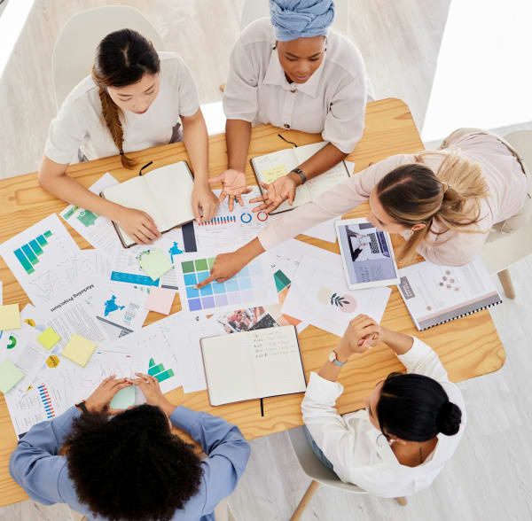 Marketing or advertising team planning a work strategy at a table in a startup company. Diversity,