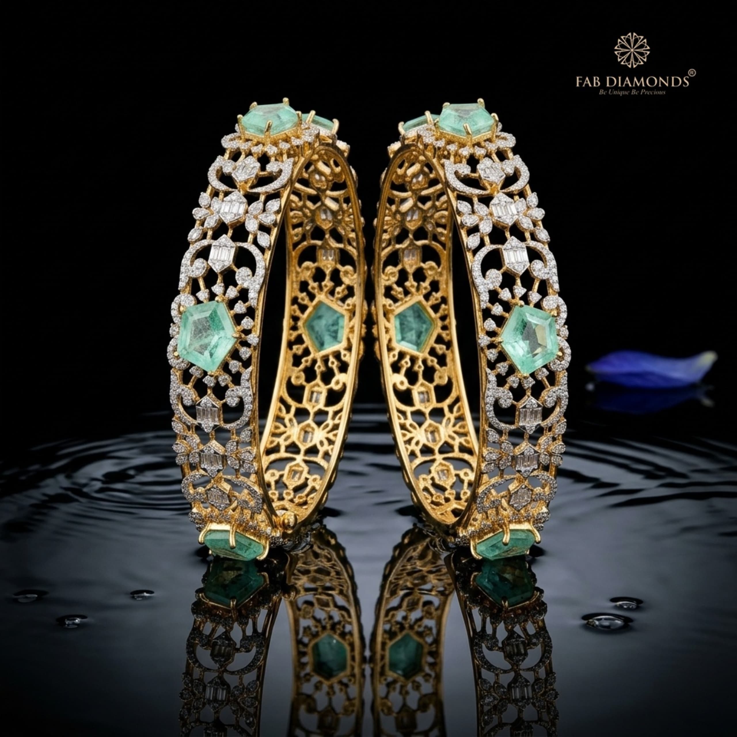 A pair of 18KT gold bangles with emerald centres and diamond openwork scrolls