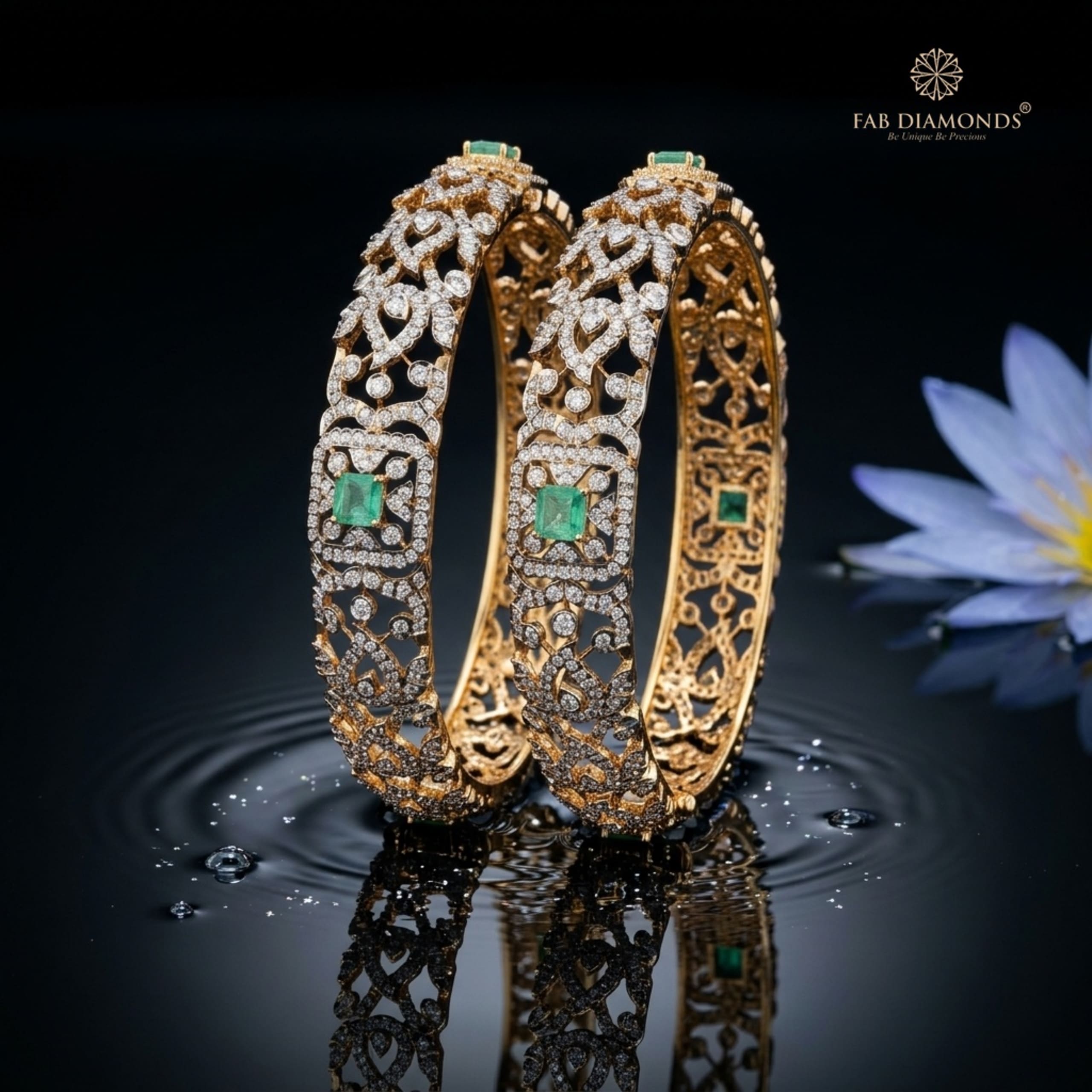 A pair of 18KT diamond bangles with emerald accents and flowing scrollwork